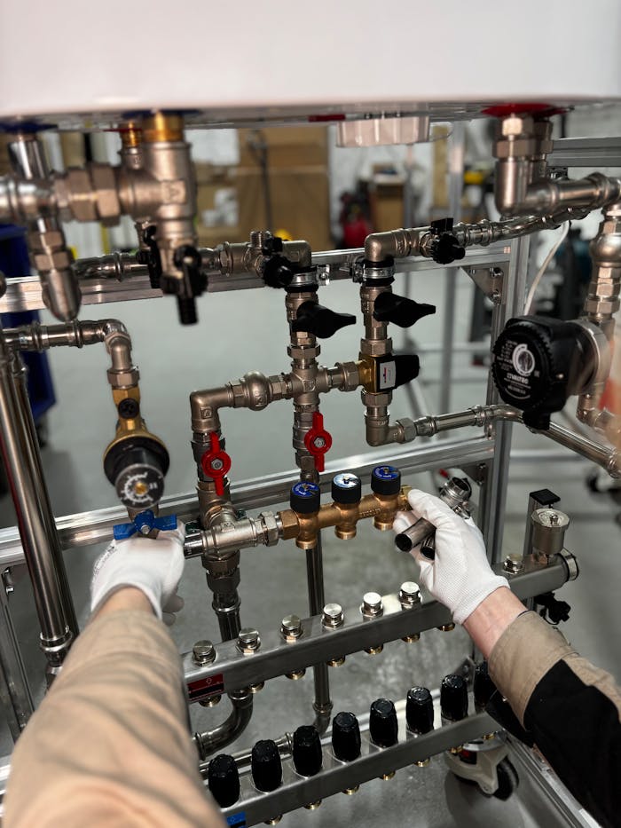 Artisan qui règle les vannes d’une installation de chauffage